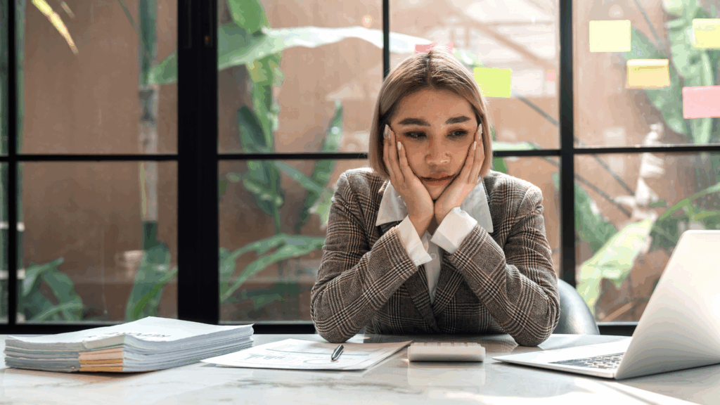 A frustrated business woman with her hands on her face.