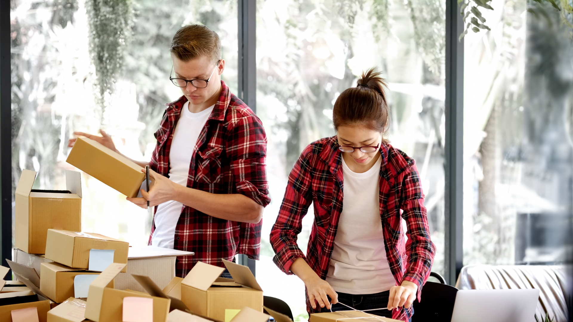 Two business owners packing boxes in their home office.