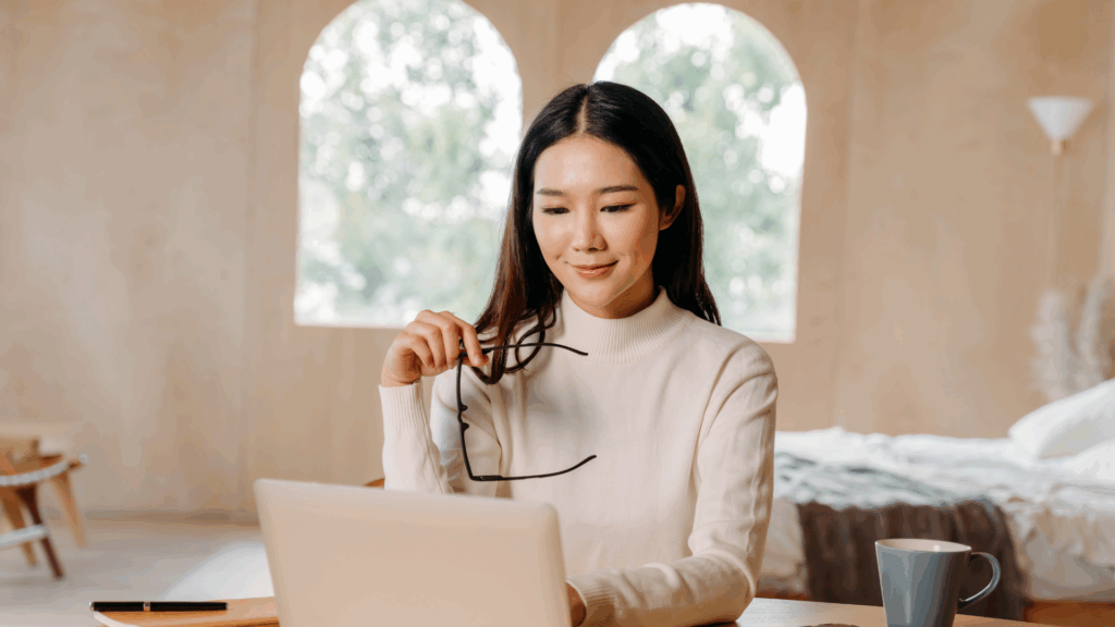 An Asian woman researching marketing advice on her computer.