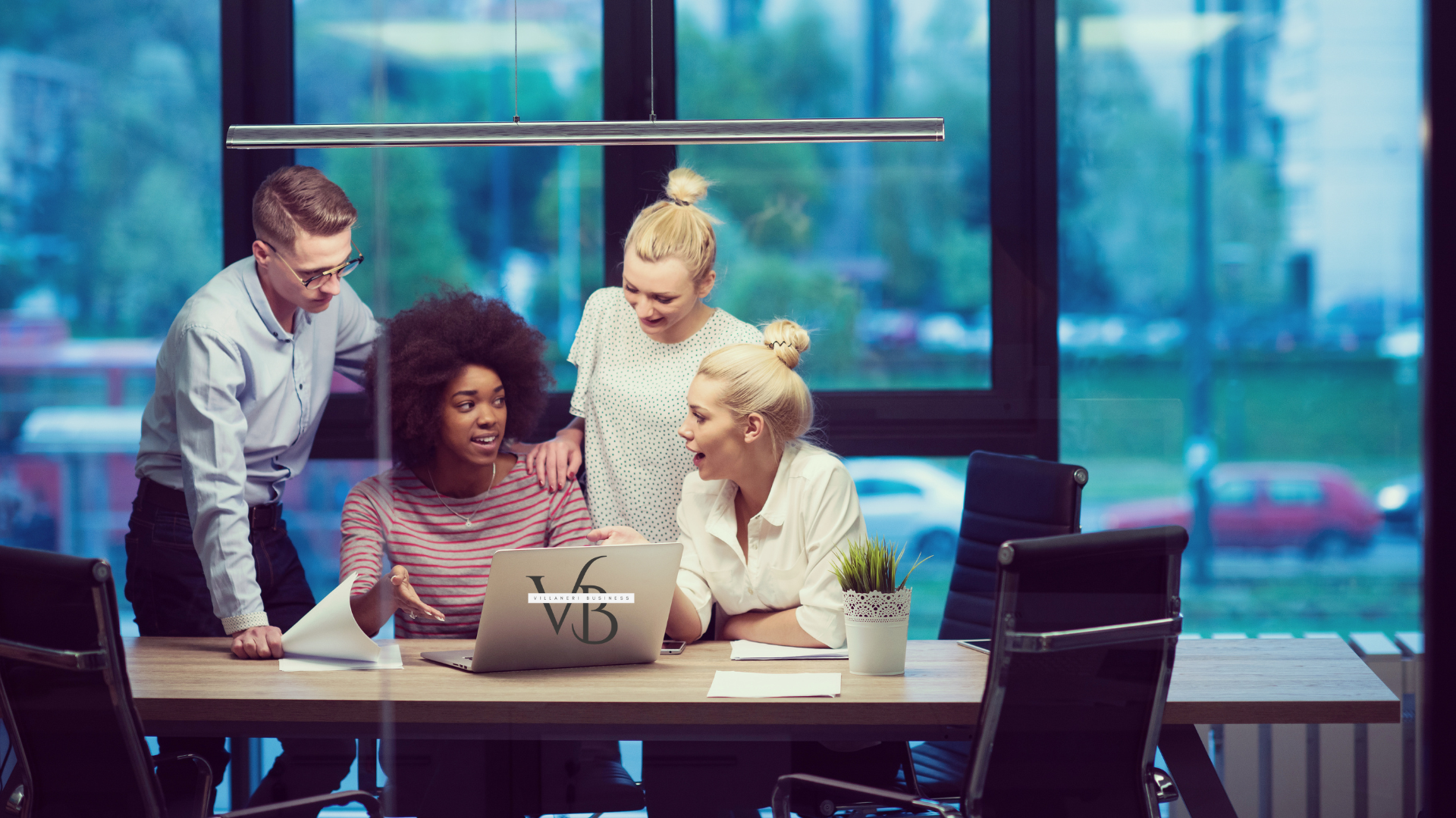 A business team talking about ideas around a computer.